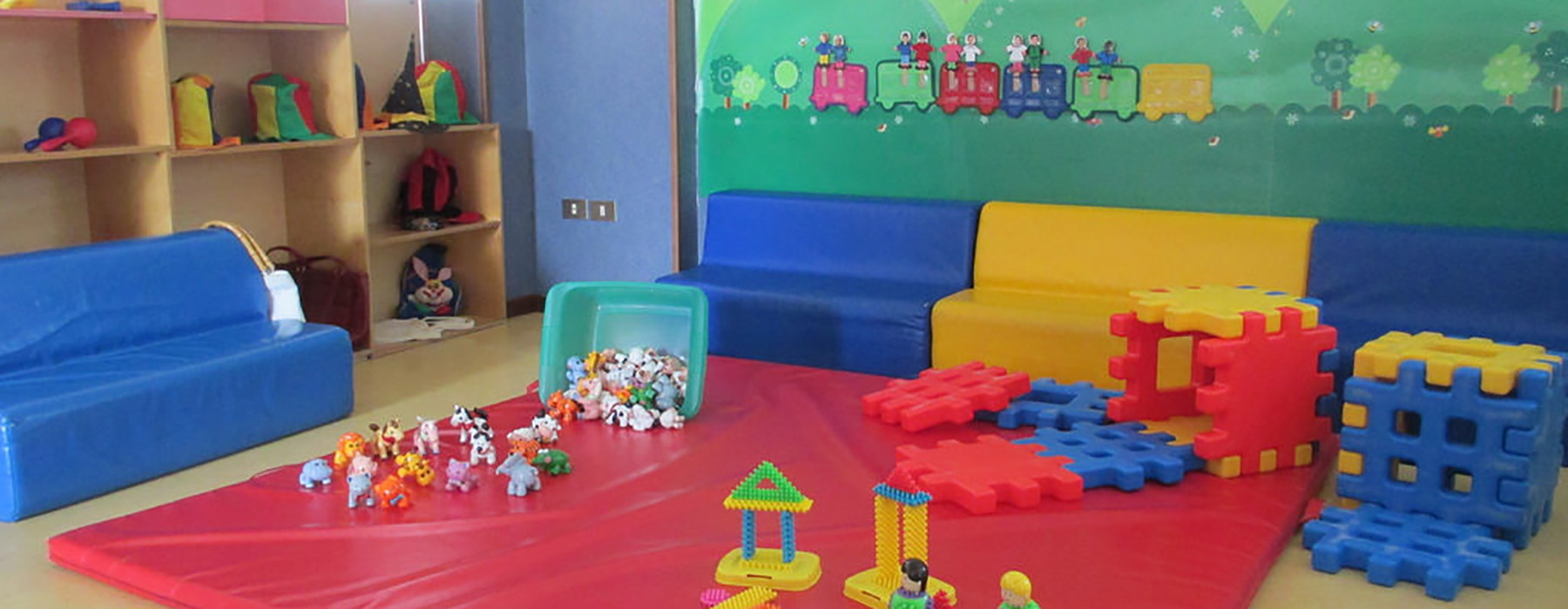 Sala di un asilo nido con giocattoli e tappetini