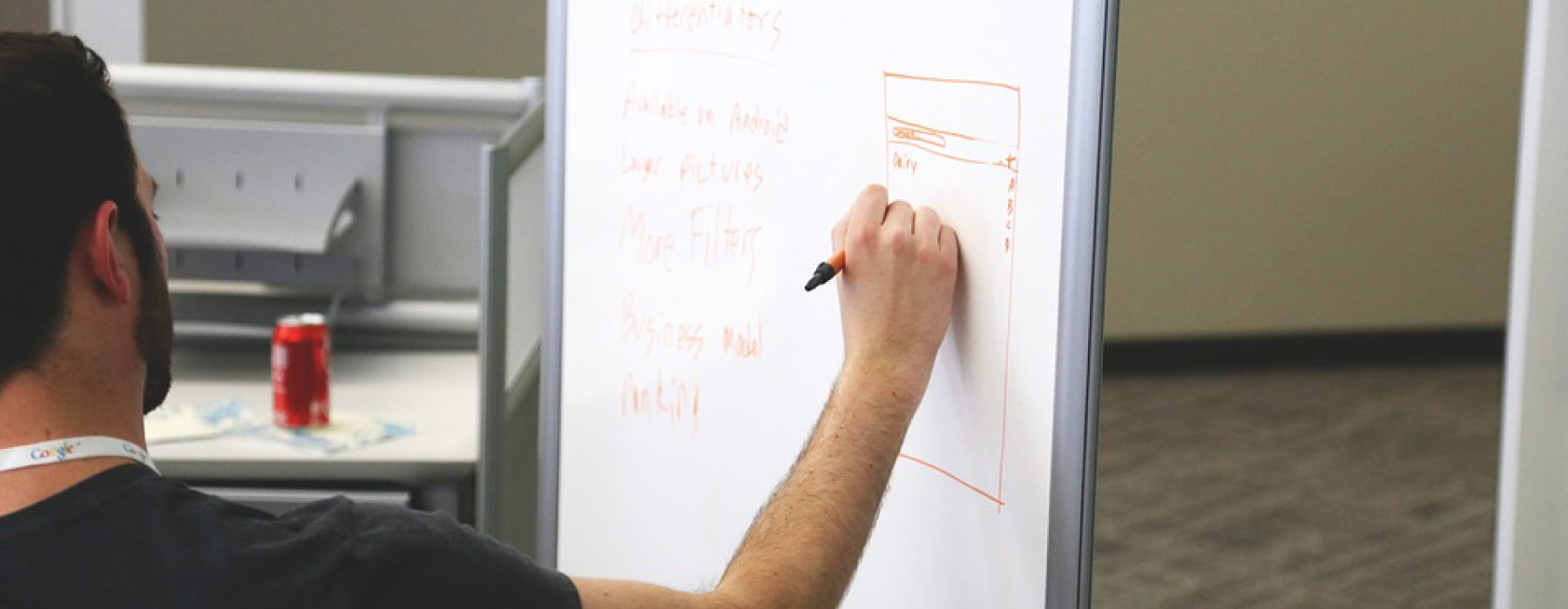 Ragazzo che scrive su una lavagna con un pennarello