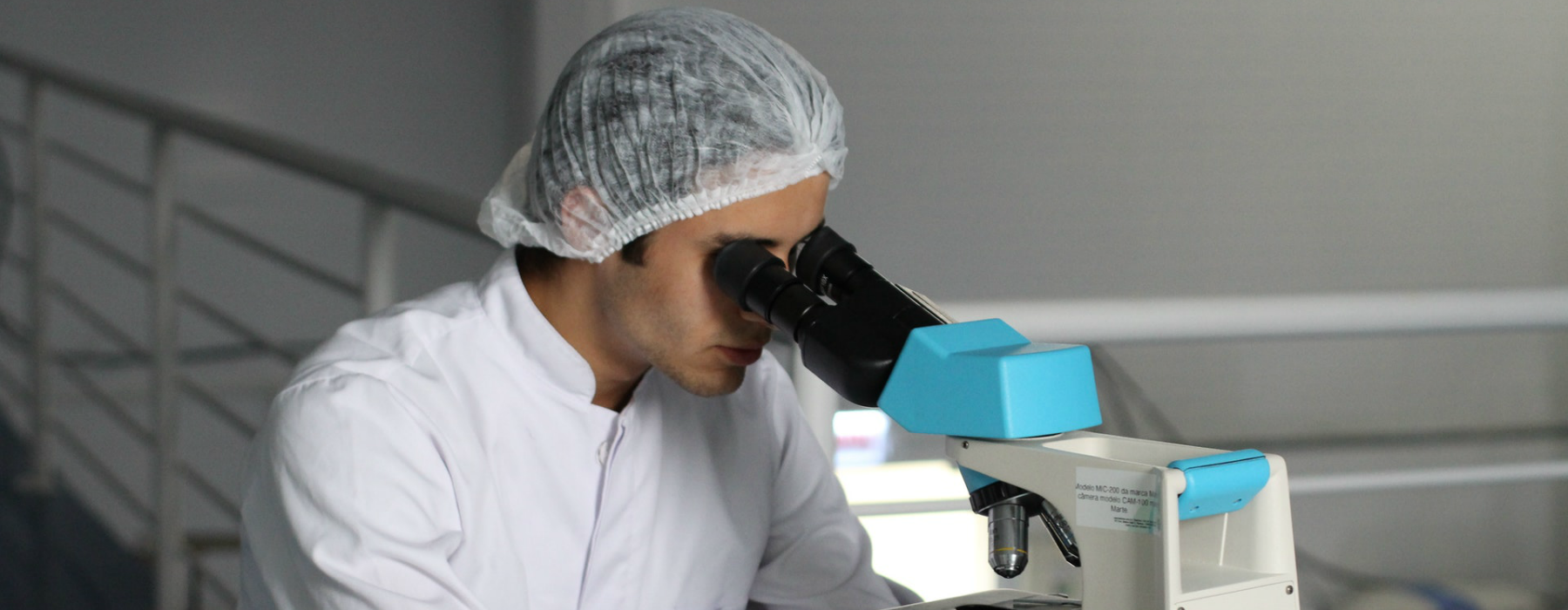 Ricercatore in laboratorio con microscopio Ricercatore in laboratorio con microscopio