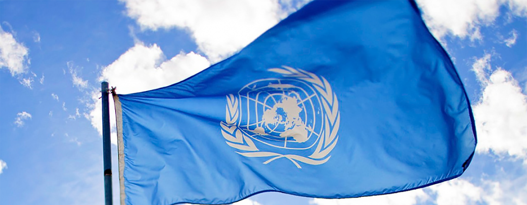 Bandiera delle Nazioni Unite sventola con sullo sfondo cielo e nuvole