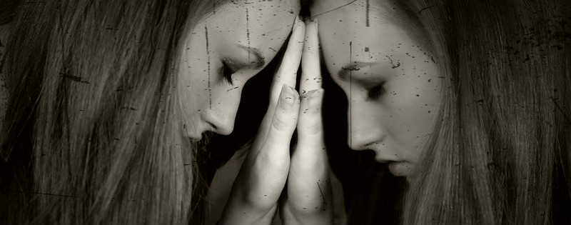 Ragazza triste riflessa allo specchio