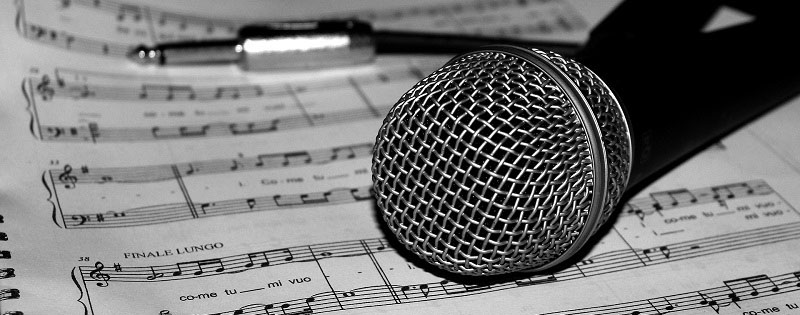 Microfono su spartito musicale in bianco e nero
