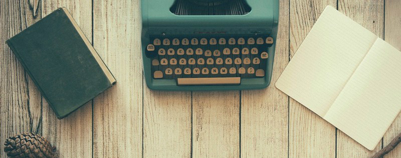 Scrivania con macchina da scrivere, quaderno e fogli