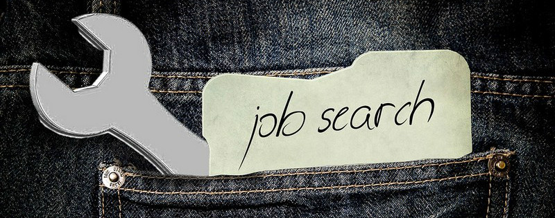 Tasca di jeans con chiave inglese e biglietto con scritto "job search"