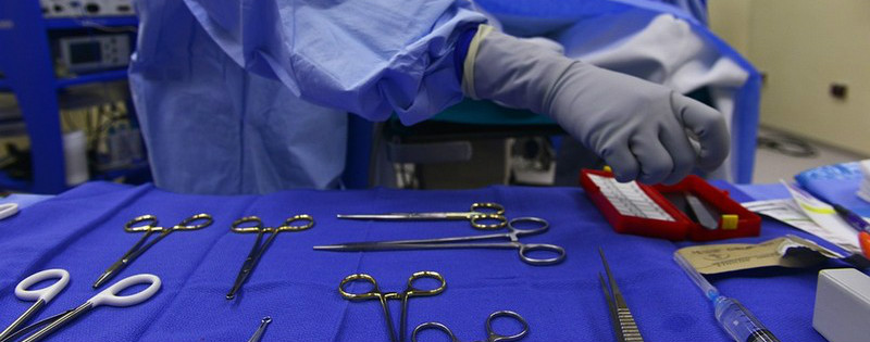 Immagine di un dottore o dottoressa davanti a strumenti medici durante un'operazione chirurgica