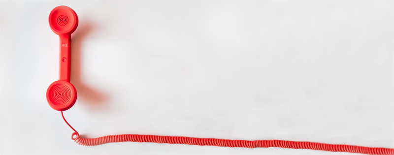 Cornetta di telefono rossa su sfondo bianco